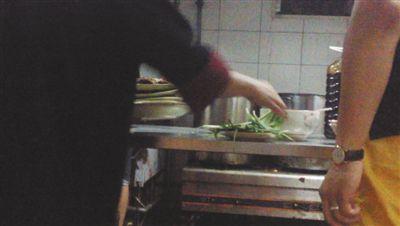 7月23日，漢麗軒烤肉超市昌平店，服務(wù)員將幾盤顧客剩菜（左手中疊在一起的是幾盤肉，其右手正整理韭菜）端回后廚，進行整理后準備再送往餐廳自助取餐區(qū)供顧客食用。